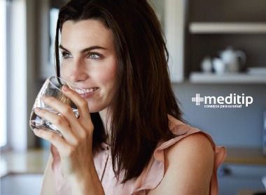 Mujer tomando agua: función de la orina en el sistema urinario