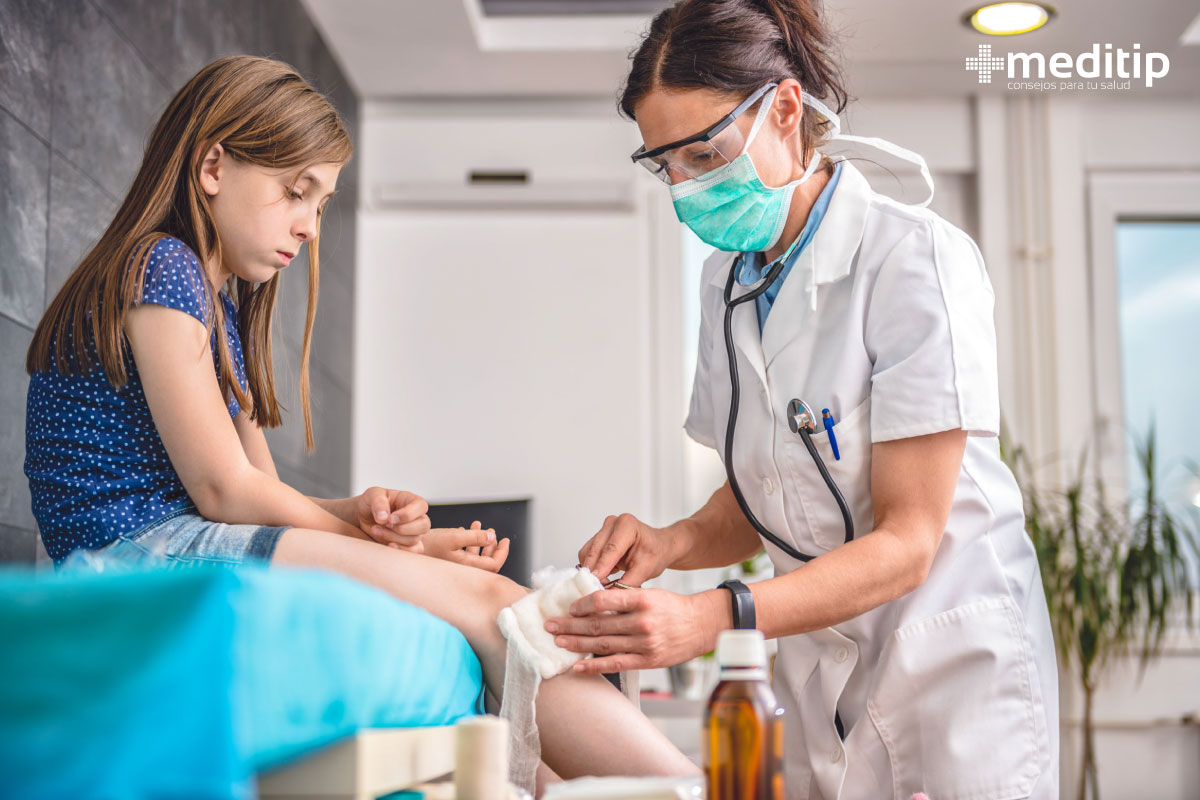 Tratamiento de heridas en niños: profesional de la salud curando herida en la rodilla